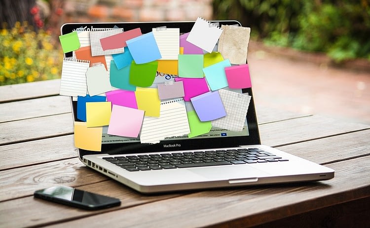 open laptop with color sticky notes covering the screen