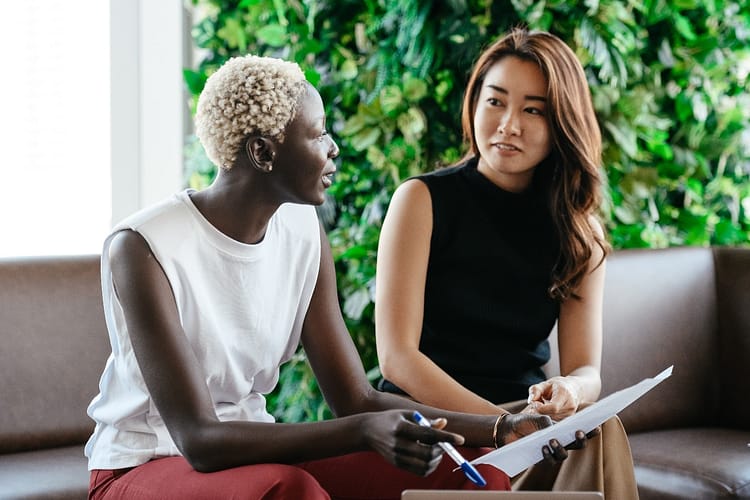 black and asian women entrepreneur partners talking